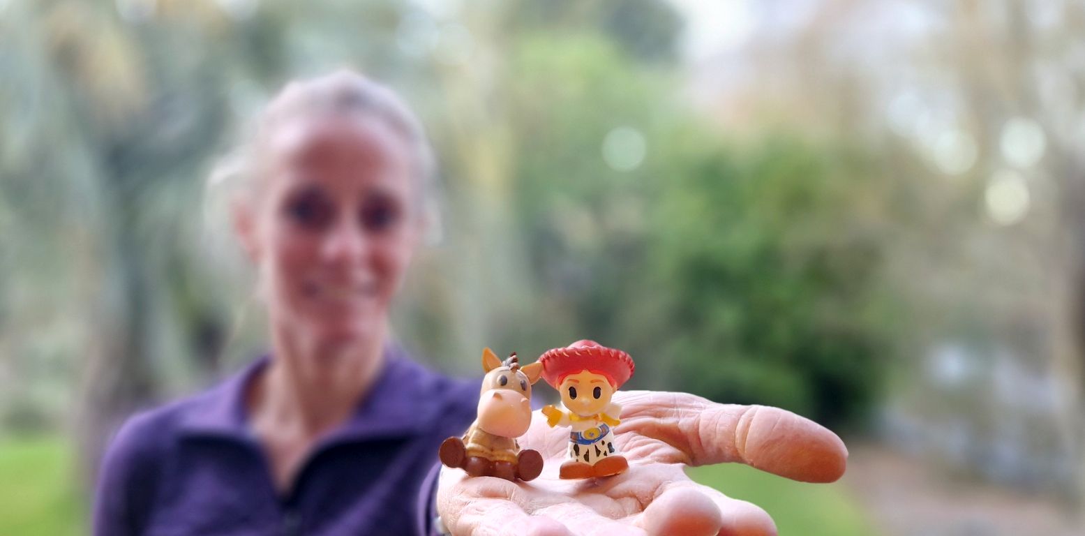 woman in a garden holding two Ooshies into the camera